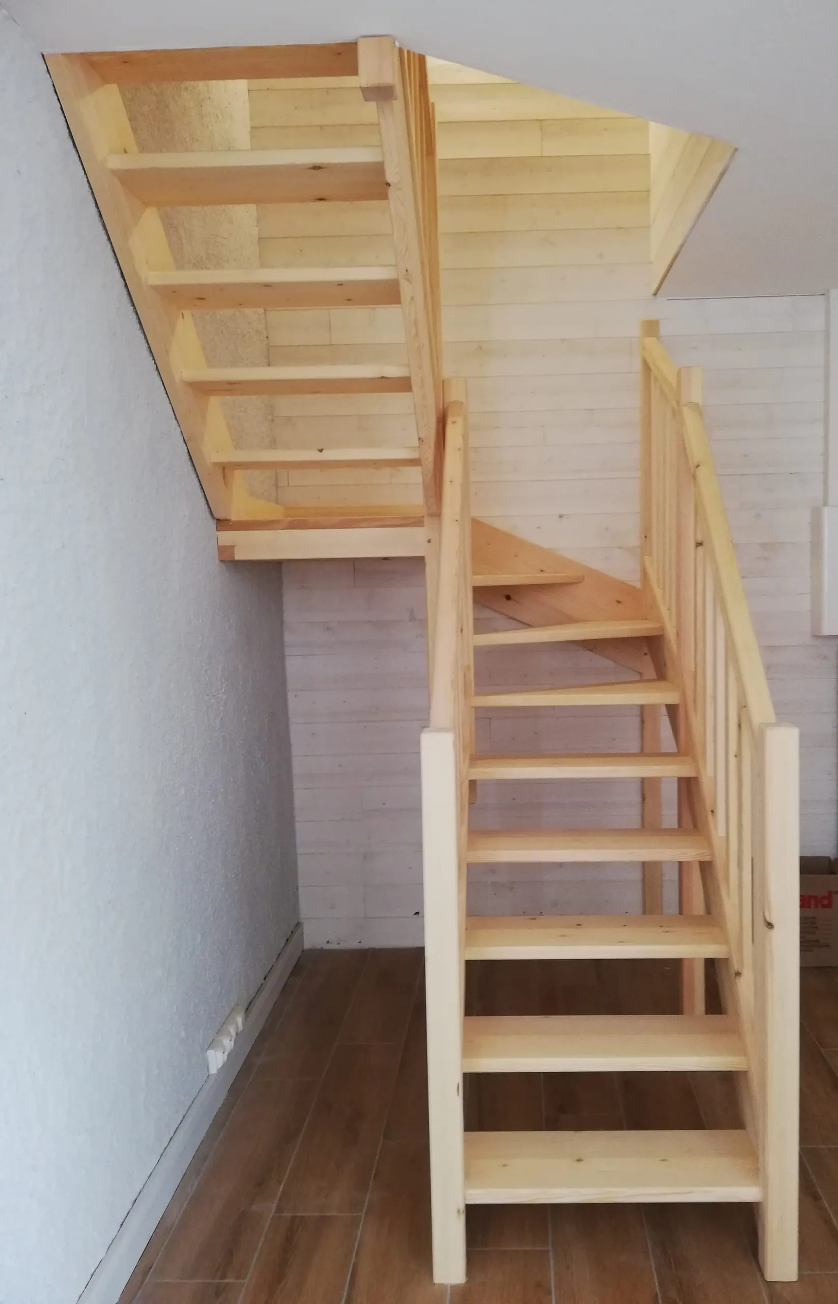 Escalier intérieur en bois clair avec marches ouvertes et garde-corps