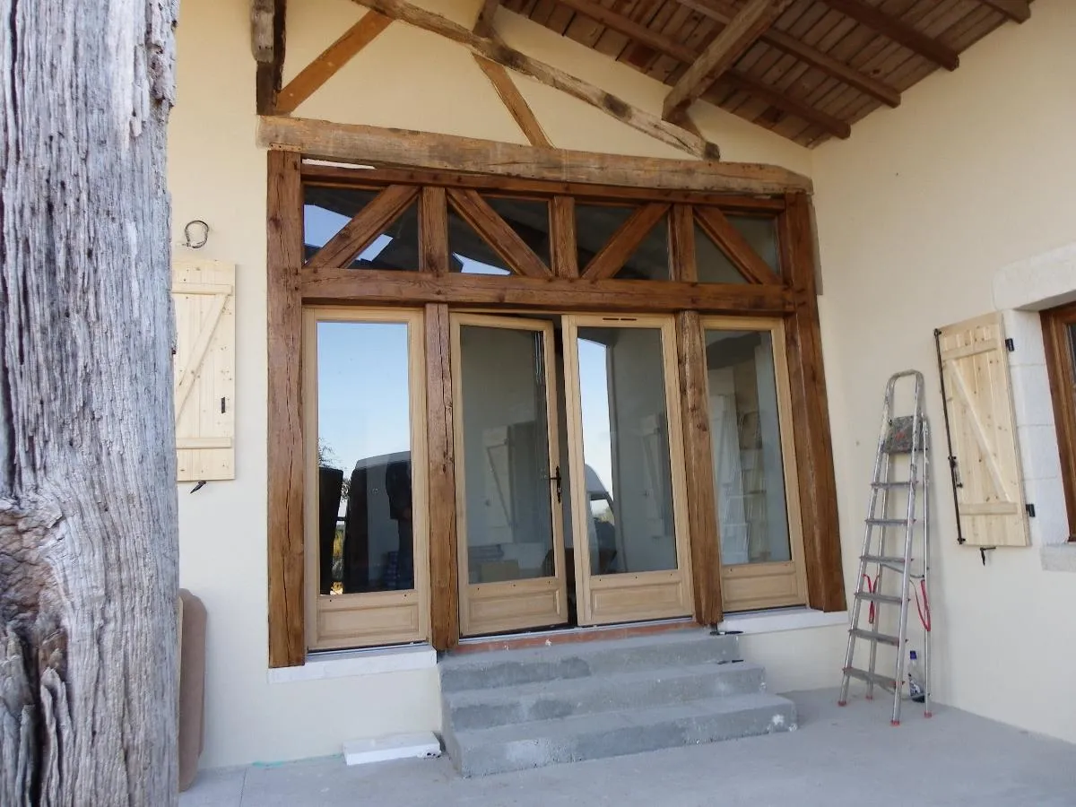 Menuiserie vitrée en bois intégrée dans une façade à colombages
